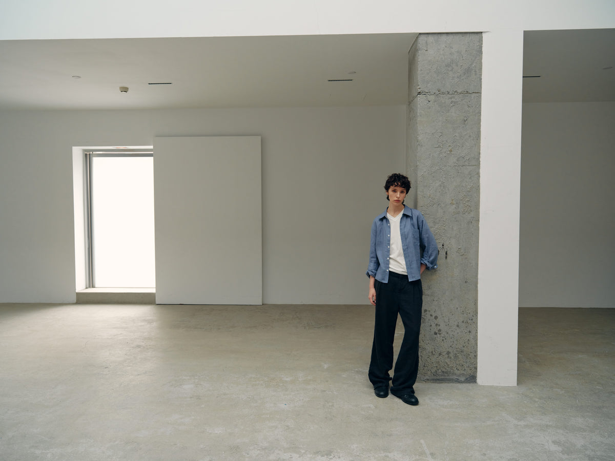 Retro21 Autumn Winter 2026, model in a blue shirt beside a concrete column